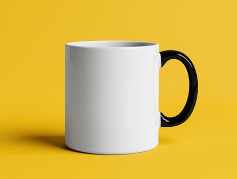 White mug with black handle on yellow background photo