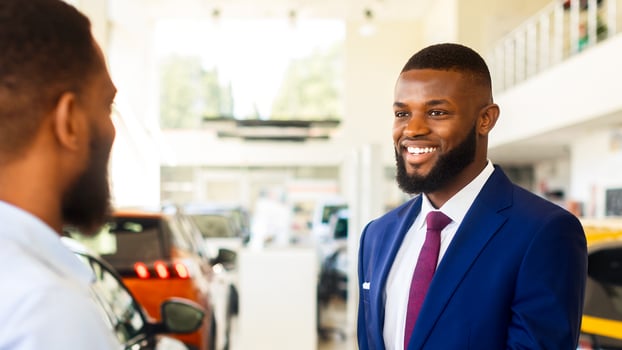Car Sales Or Rent. Black Manager In Suit Giving Keys To Male Customer In Dealership Center, Young African American Man Purchasing Or Renting New Automobile In Modern Showroom, Selective Focus photo