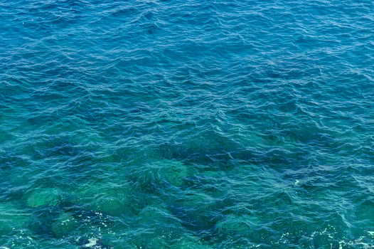 The shimmering turquoise waves of a tranquil ocean on a sunny day. photo