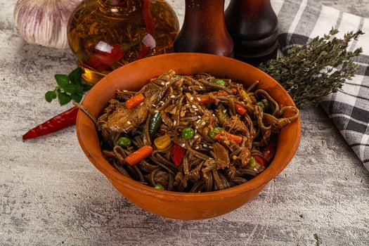 A bowl of noodles with vegetables and garlic photo