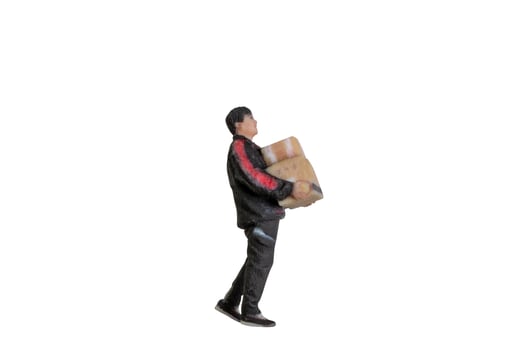 Miniature figurine of a delivery worker carrying a packages isolated with clipping path photo
