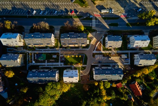 Top view of modern residential neighborhood with contemporary apartment buildings, green spaces, parking areas and well-maintained pathways on sunny day photo