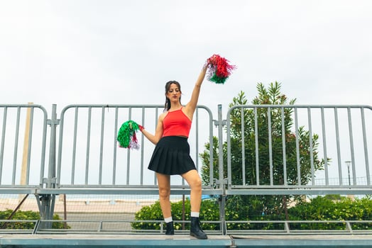 Cheerleader Girl Cheers Her Heart Team With Pompon In Football Stadium photo