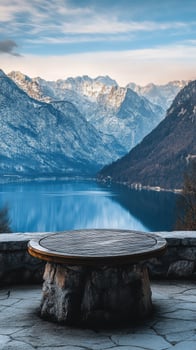 A stone table sitting in front of a lake and mountains photo