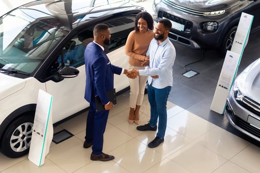 Black Salesman Shaking Hands With Customer Couple In Modern Dealership Center, Top Vie Shot Of Auto Salon Manager Handshaking With Clients After Successful Deal, Selling New Auto In Showroom photo