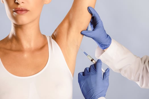 Hyperhidrosis Treatment. Woman receiving underarm shot. Armpit injections to prevent excessive sweating, cropped. Plastic surgeon in gloves making jab at arm pits against profuse perspiration disorder photo