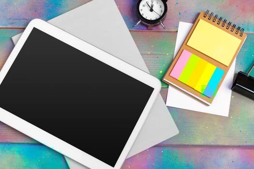 Modern blank digital tablet with papers and pen on a wooden desk. Top view. photo