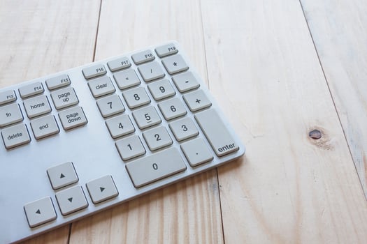 Computer keyboard on top of wooden desk. photo