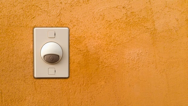 Doorbell or buzzer on mounted on orange wall photo
