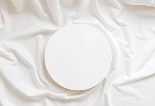 Top view of round podium display for cosmetics product presentation on smooth elegant white cloth fabric background photo