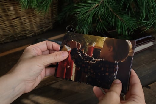 Woman looking through printed Christmas photographs for family picture album. photo