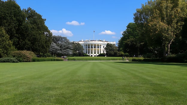 Iconic historical government building surrounded by lush green garden under a clear blue sky photo