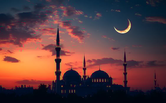 The crescent moon is seen in the sky over a mosque photo