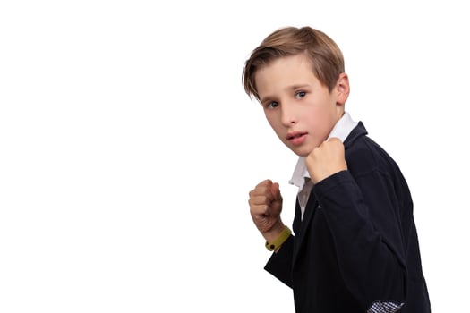 Portrait of a boy who is defending himself, ready to fight on a white background. photo