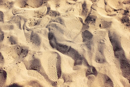 Yellow sand with footprints. Beach sand background. photo