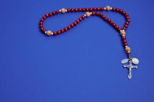 Rosary beads on a blue background for prayer and meditation experience photo
