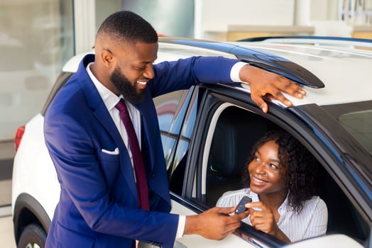 Happy Black Lady Taking Car Key From Dealership Office Manager, Joyful African American Woman Sitting Inside Of Luxury Vehicle And Smiling Through Window, Enjoying Buying New Automobile, Closeup photo