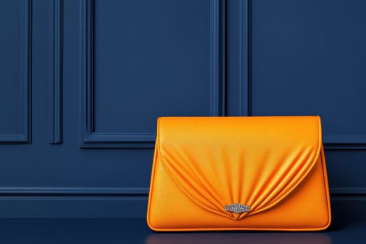 Bright orange clutch bag with bold asymmetrical lines on dark blue background showcasing modern elegance and style for fashionable occasions photo