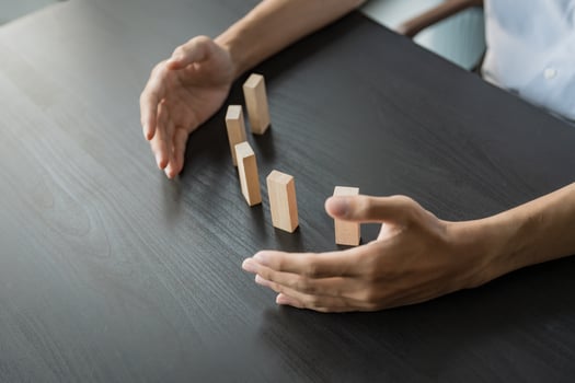 a person is holding wooden blocks on a table. photo