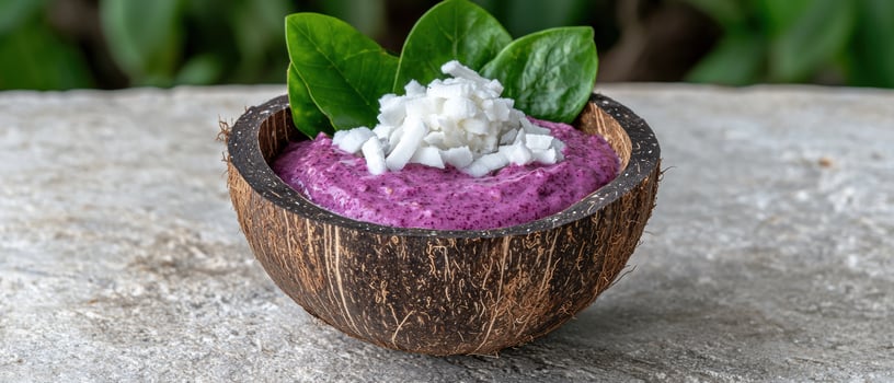 Purple smoothie bowl with coconut flakes and green leaves photo