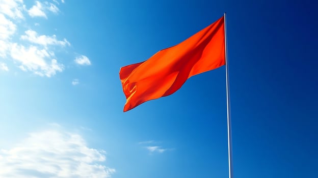 Bold Red Flag Against Bright Blue Sky Symbolizing Courage and Determination on a Sunny Day photo