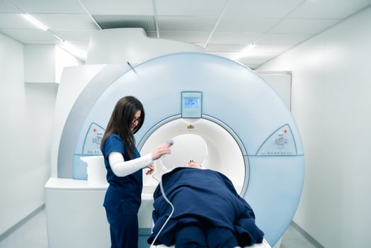 A nurse or medical technician prepares a patient for an MRI scan or MRI scanner photo