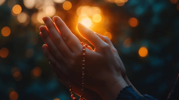 Hands in prayer holding rosary beads with soft glowing light, symbolizing devotion and faith during sacred rituals. photo