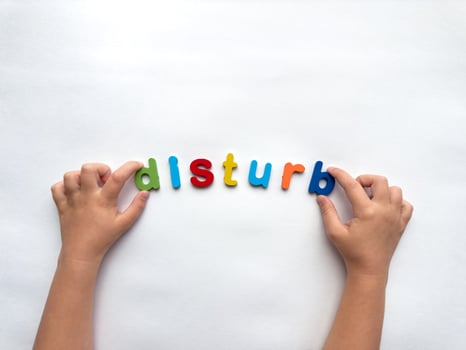 Colorful letters form the word disturb on white background with hands photo