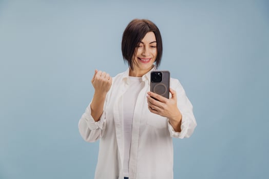 Enthusiastic mature businesswoman celebrating success on call photo