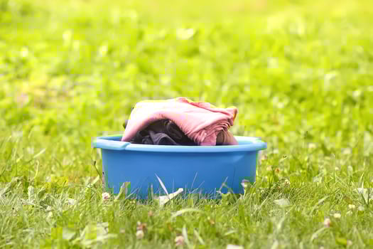 Stack of laundry in the large plastic cup outdoors photo