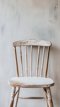 Distressed White Wooden Chair Against A Textured Wall photo