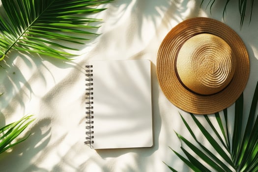 Notebook, tropical leaves and straw hat photo