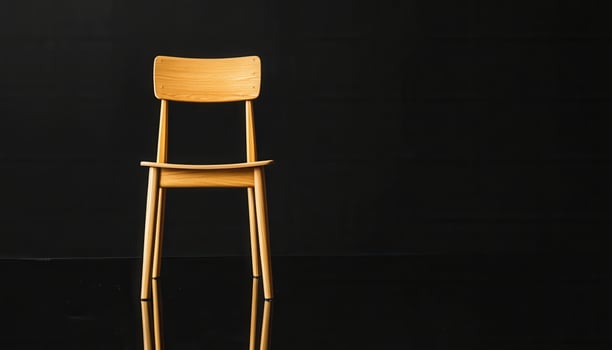 Simple Wooden Chair Against Black Background photo