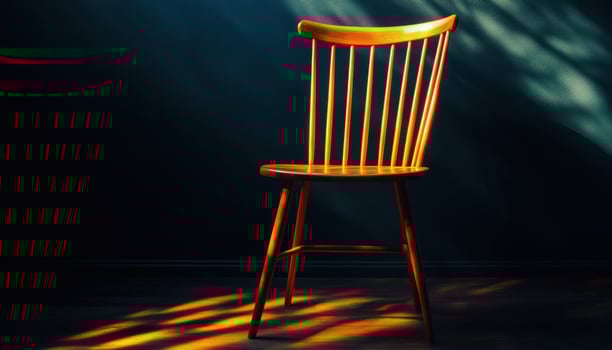 Wooden Chair Illuminated By Sunlight In A Dark Room photo