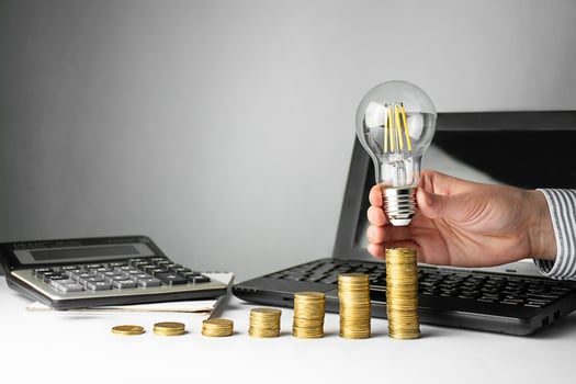 Business concept. A hand holds a lamp over coins on a light background. Business ideas, brainstorming photo