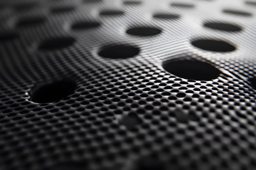 Abstract Black Perforated Metallic Surface with Hexagonal Patterns for Modern Design photo