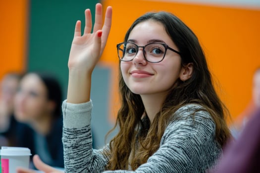 Ypung woman raises hand during classroom discussion photo