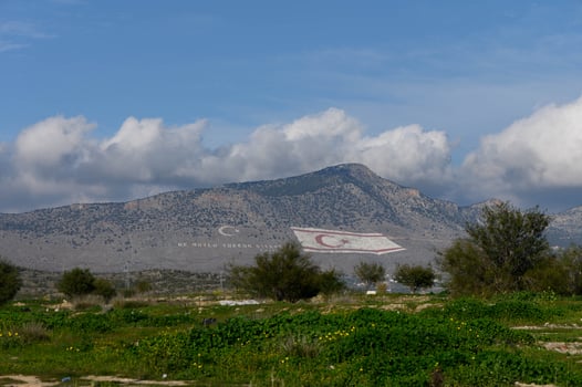 Majestic mountains adorned with a vibrant flag in the serene landscape of Northern Cyprus photo