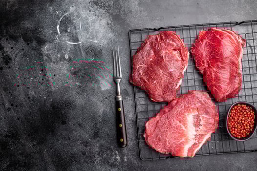Raw Beef cheeks, fresh veal meat. black background. top view photo