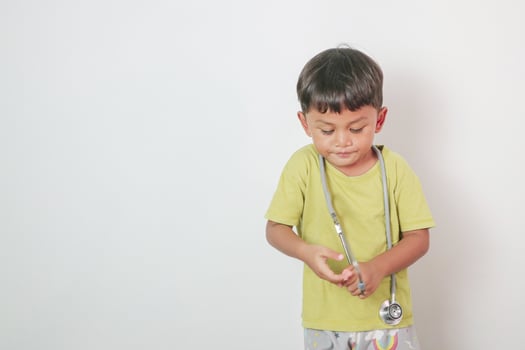 asian Little kid wearing doctor uniform costume and stethoscope photo