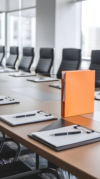 Modern conference room with wooden table, orange folder, and professional atmosphere. Vertical Mobile Wallpaper photo