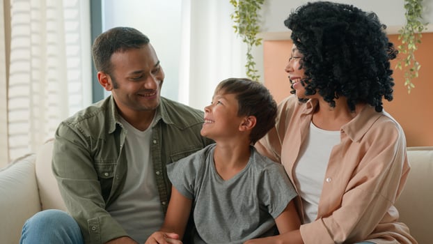 African American mother and father loving mum dad family portrait multiracial couple parents and Caucasian adopted child kid looking at each other smiling hug adorable cute little boy son childcare photo