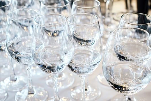 Many wine glasses filled with sparkling water on table for celebration photo