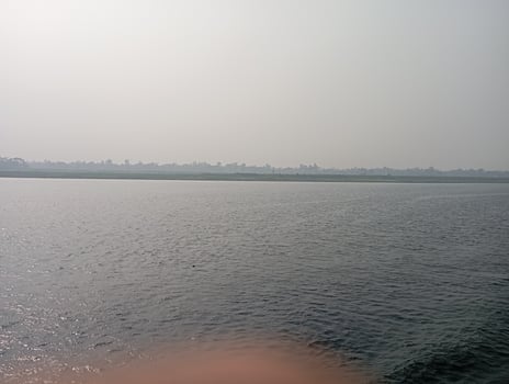 a person is standing on the shore of a body of water photo