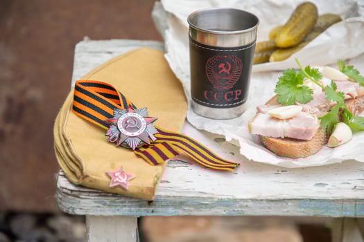 St. George ribbon, the order of the Great Patriotic War, the holiday Victory Day May 9, still life on a shabby chair with a glass of vodka with an inscription in Russian USSR and snacks, photo