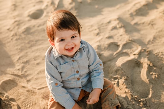 Infant cute boy exploring the sandy river shore in spring. photo
