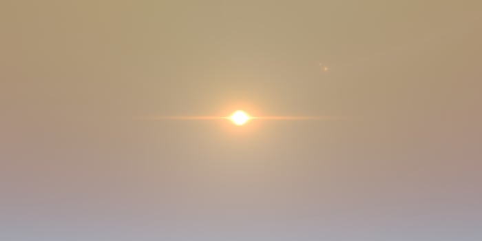 Ethereal sunrise over misty horizon with golden glow and gentle light photo
