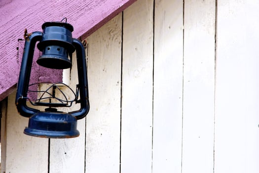 A Vintage Black Lantern Hangs Beautifully on a Rustic Wooden Wall Surrounded by History photo