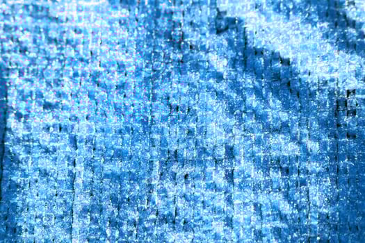 Blue tarpaulin covered with frost in winter frosty morning close-up photo