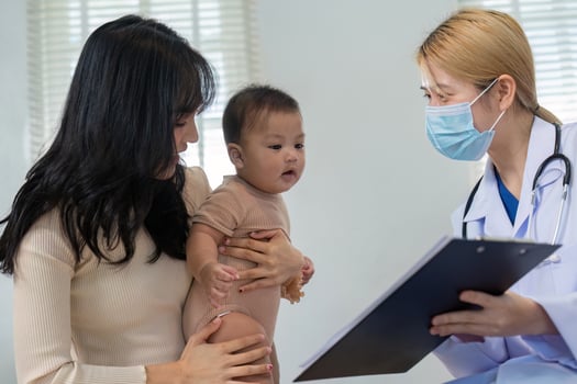 Pediatric consultation with doctor, parent, and baby in a medical setting photo